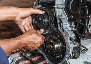 Professional car mechanic working on transmission